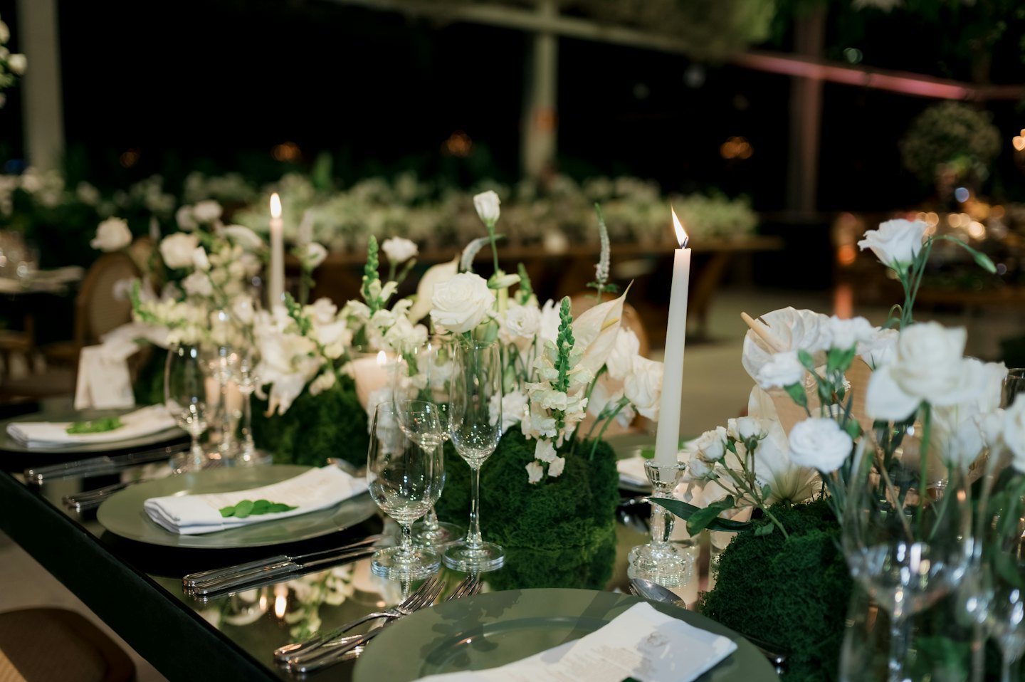 Elegant dining table set with candles and floral centerpieces.