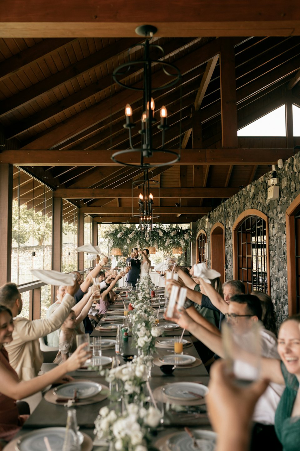 Newlyweds share a toast with guests at a wedding reception.
